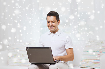 Image showing happy man working with laptop computer at home