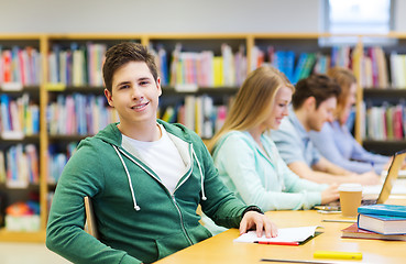 Image showing happy student boy reading books in library