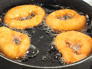Image showing Closeup of doughnuts boiling in kettle of oil