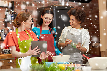 Image showing happy women with tablet pc cooking in kitchen