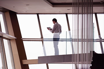 Image showing young successful business man in penthouse apartment working on 