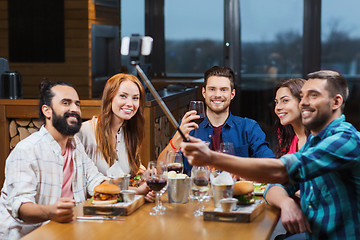 Image showing friends taking selfie by smartphone at restaurant