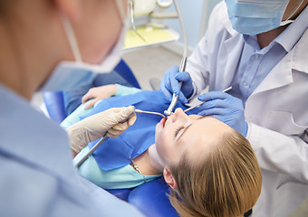 Image showing close up of dentist treating female patient teeth