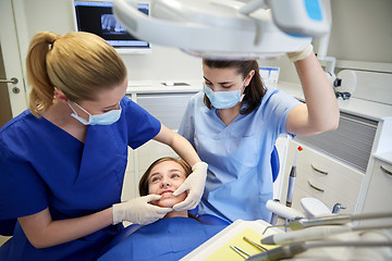 Image showing happy female dentist with patient girl at clinic