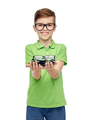 Image showing happy boy in green polo t-shirt holding eyeglasses