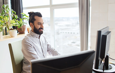 Image showing happy creative male office worker with computer