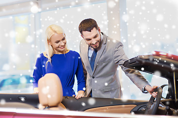 Image showing happy couple buying car in auto show or salon