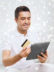 Image showing smiling man working with tablet pc at home