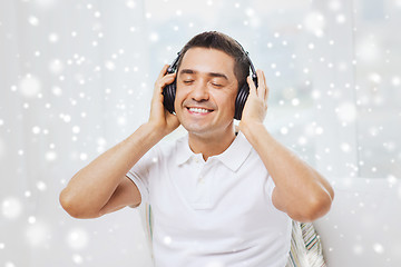 Image showing happy man in headphones listening to music at home