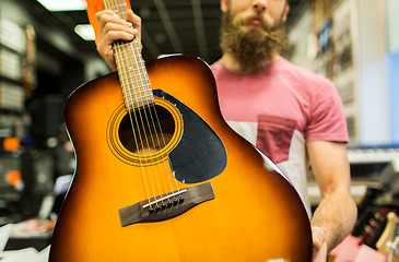 Image showing close up of man with guitar at music store