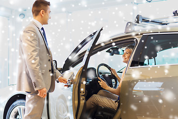 Image showing happy woman with car dealer in auto show or salon