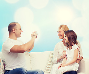 Image showing happy family with camera at home