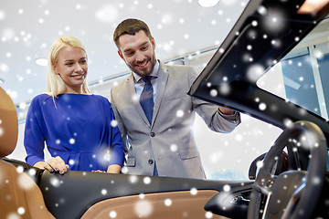 Image showing happy couple buying car in auto show or salon