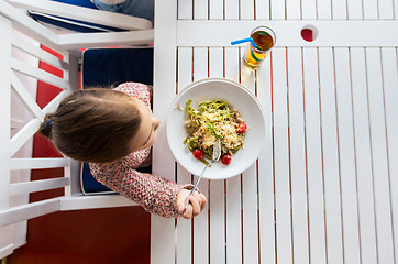 Image showing little girl eating pasta for dinner at restaurant