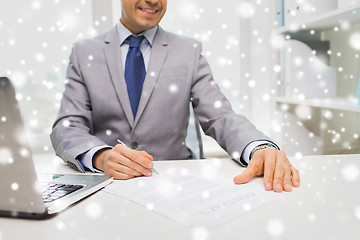 Image showing close up of businessman with laptop and papers