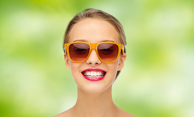 Image showing happy young woman in sunglasses with pink lipstick