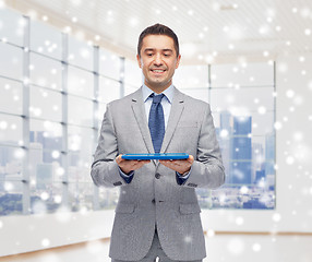 Image showing happy businessman in suit holding tablet pc