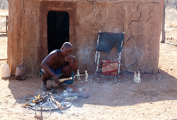 Image showing Himba man adjusts wooden souvenirs