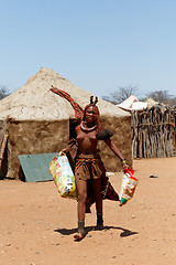 Image showing Himba girl with souvenirs for sale in traditional village