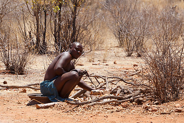 Image showing Himba man adjusts wooden souvenirs