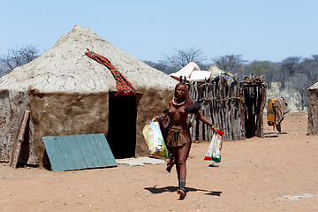 Image showing Himba girl with souvenirs for sale in traditional village