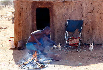 Image showing Himba man adjusts wooden souvenirs