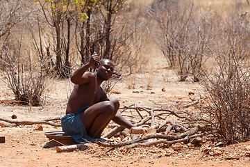 Image showing Himba man adjusts wooden souvenirs