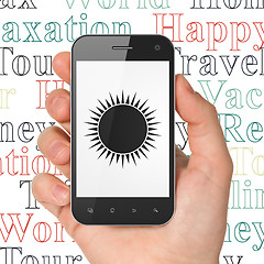 Image showing Tourism concept: Hand Holding Smartphone with Sun on display