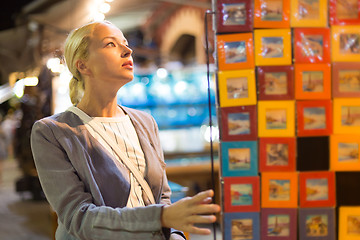 Image showing Casual blond woman shopping for vacation souvenirs.