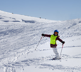 Image showing Little skier on ski slope with new fallen snow at sun day