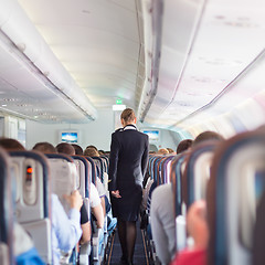 Image showing Stewardess and passengers on commercial airplane.