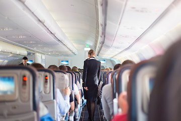 Image showing Stewardess and passengers on commercial airplane.