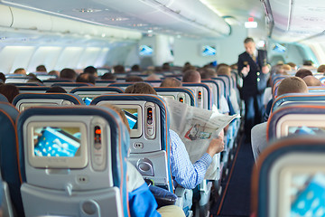 Image showing Steward and passengers on commercial airplane.