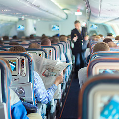 Image showing Steward and passengers on commercial airplane.