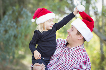 Image showing Father and Daughter Having Fun Wearing Santa Hats