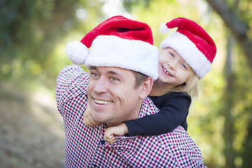 Image showing Father and Daughter Having Fun Wearing Santa Hats