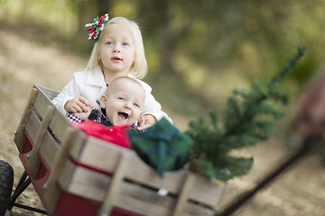 Image showing Baby Brother and Sister Pulled in Wagon with Christmas Tree