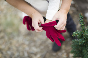 Image showing Mother Putting Red Mittens On Child