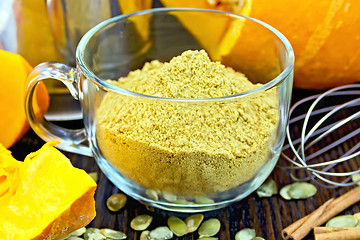 Image showing Flour pumpkin in glass cup with seeds and a mixer on board