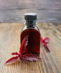 Image showing Oil with amaranth on dark board