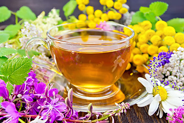 Image showing Tea from flowers in glass cup on board