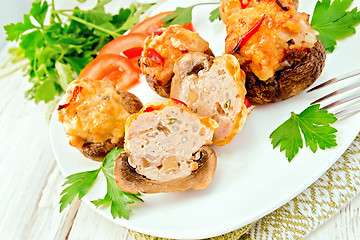 Image showing Champignons stuffed meat cut in white plate on board