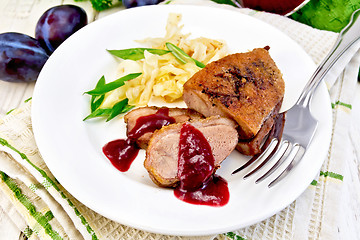 Image showing Duck breast with plum sauce and green onions in plate on napkin