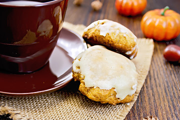 Image showing Cookies pumpkin with cup on sacking