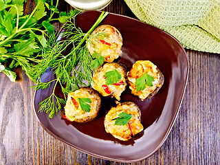 Image showing Champignons stuffed meat in brown plate on board top