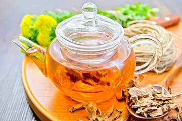 Image showing Tea of Rhodiola rosea in glass teapot on tray with spoon