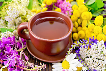 Image showing Tea from flowers in clay cup on board