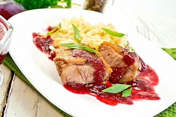 Image showing Duck breast with plum sauce and cabbage in plate on green napkin