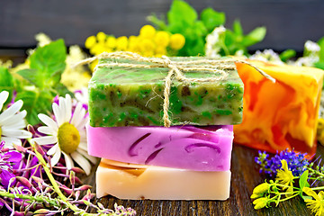 Image showing Soap homemade with flowers and leaves on board