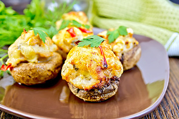 Image showing Champignons stuffed meat with parsley in brown plate on board